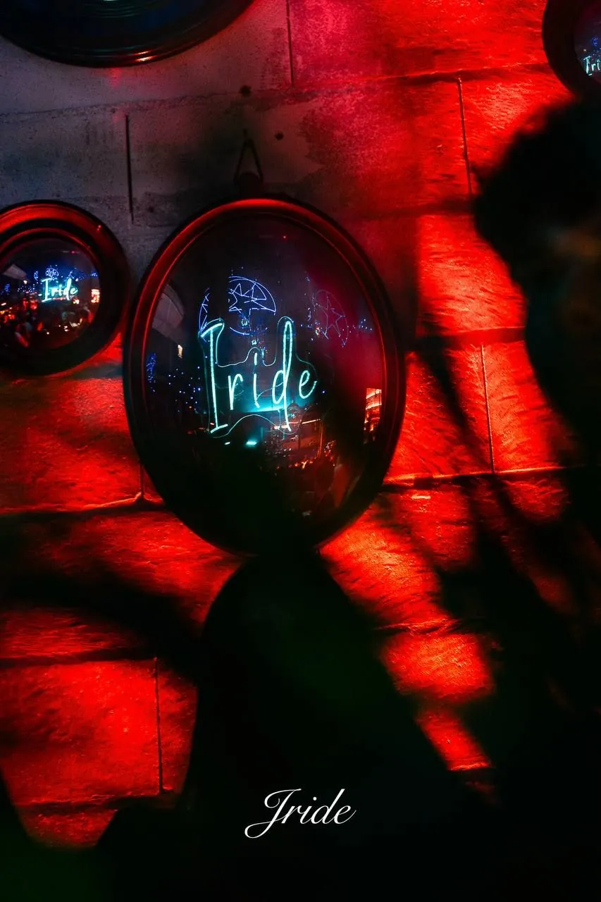 L'insegna al neon di Iride su una parete illuminata di rosso
