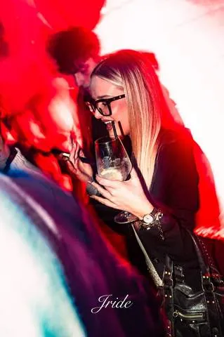 Ragazza con gli occhiali tra le luci rosse