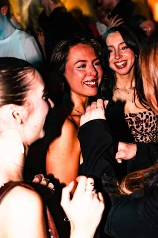 Amiche che ridono in mezzo alla folla