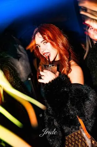Ragazza con un drink tra luci colorate