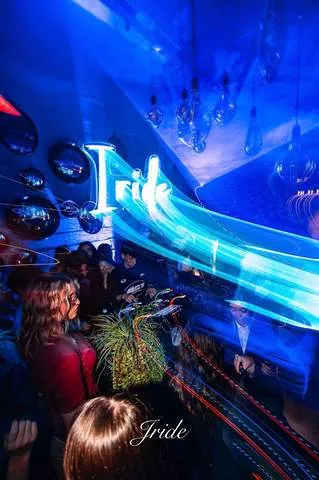 L'insegna Iride al neon tra scie di luce blu