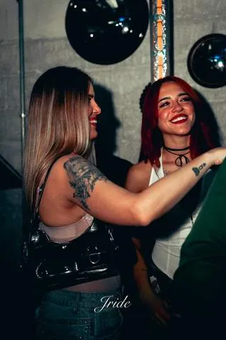 Due amiche che ballano vicino alle sfere specchiate