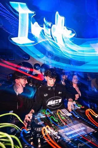 DJ in consolle sotto l'insegna Iride illuminata